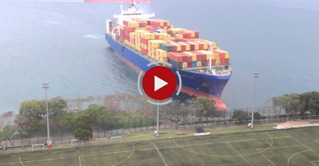 Container Ship Sails Straight To Shore By University Football Field